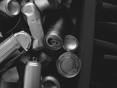 Crushed and intact metal cans in bin.
