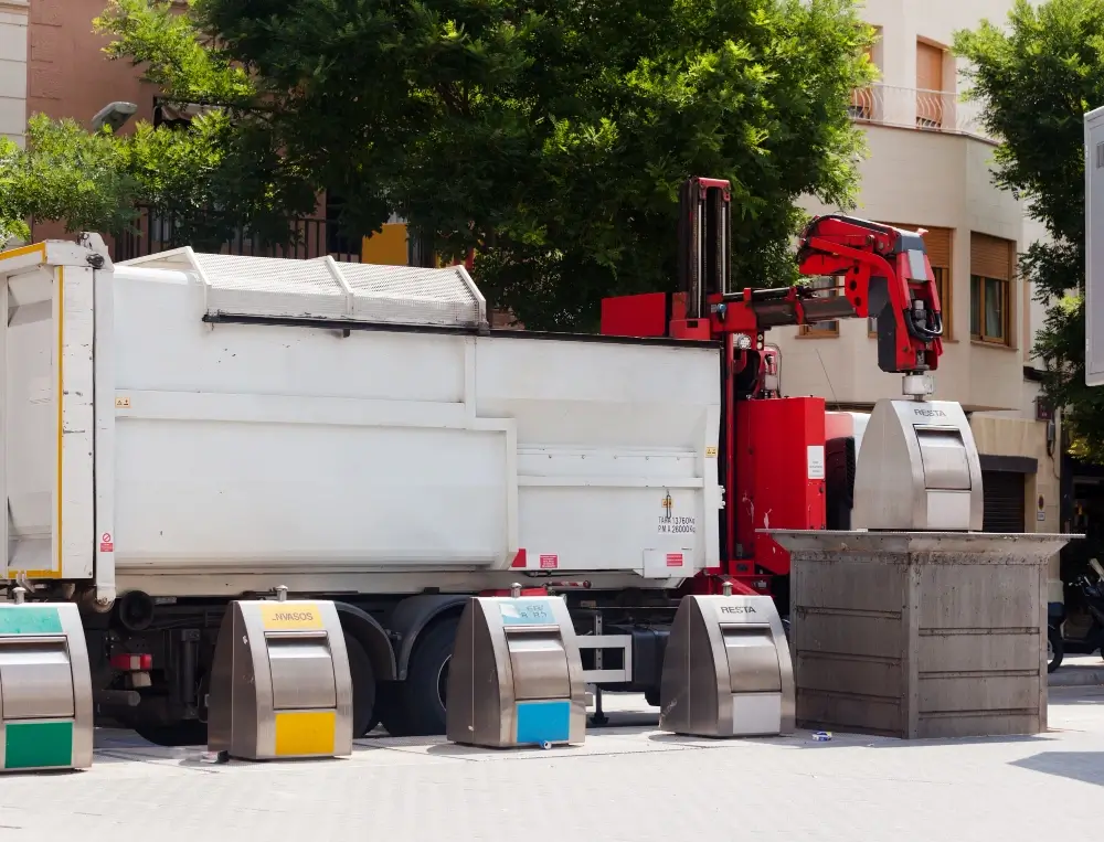 Garbage truck collecting underground waste containers.