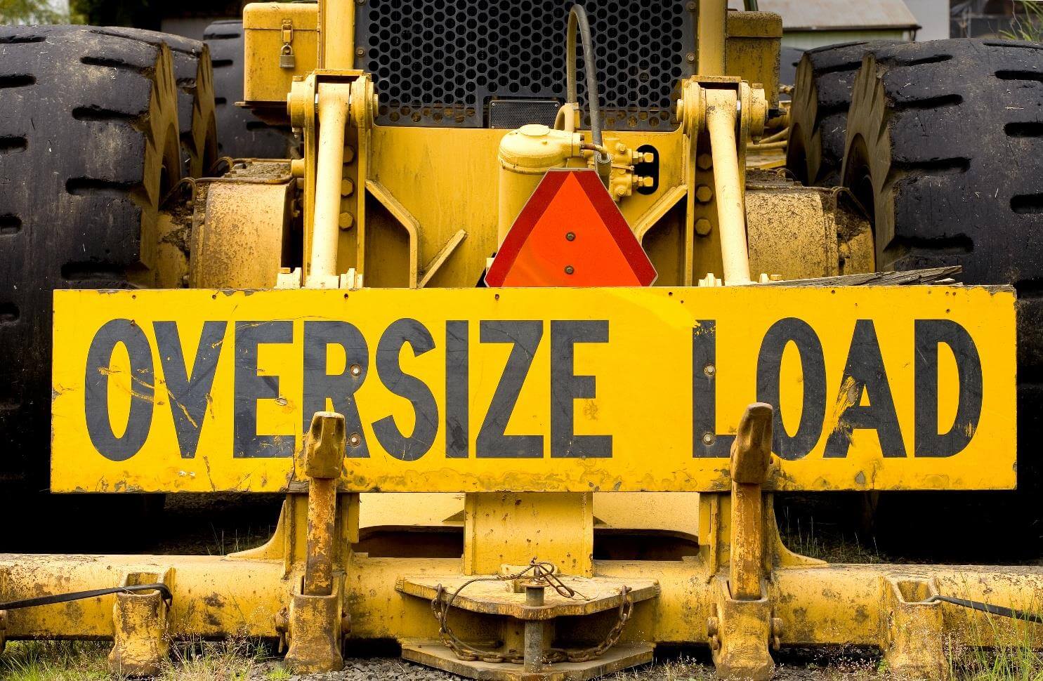 Yellow vehicle with "Oversize Load" sign.